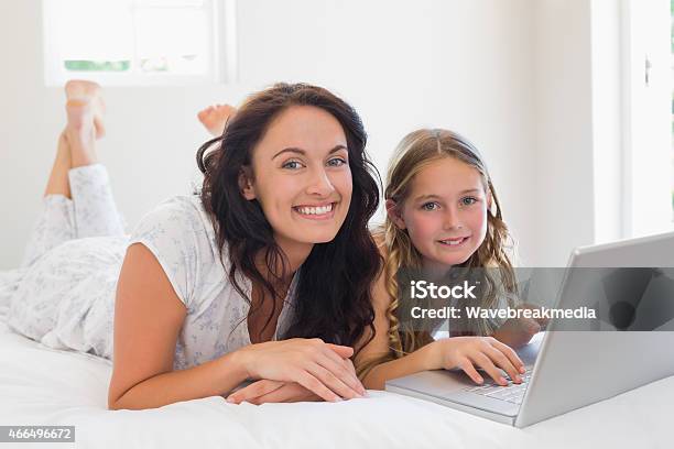 Mother And Daughter With Laptop Lying In Bed Stock Photo - Download Image Now - 20-29 Years, 2015, 25-29 Years