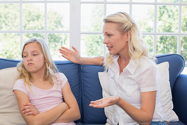 istock Mother scolding daughter on sofa 466496788