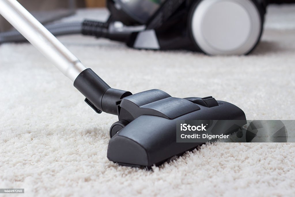 Long end of vacuum cleaner cleaning thick, white carpet Close up of the head of a modern vacuum cleaner being used while vacuuming a thick pile white carpet Vacuum Cleaner Stock Photo