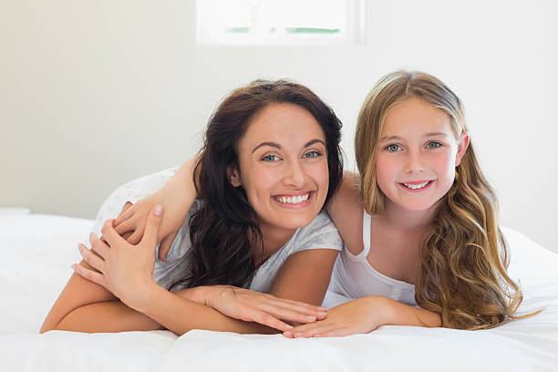 istock Smiling mother and daughter lying in bed 466497250