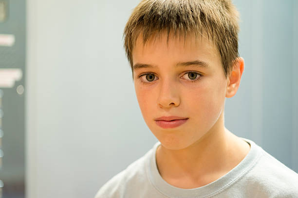 ポートレートを置く哀愁漂う 11 歳の少年、灰色の壁、ヨーロッパ - 12 13 years ストックフォトと画像