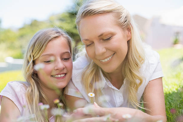 istock Mother and daughter lying in park 466497688