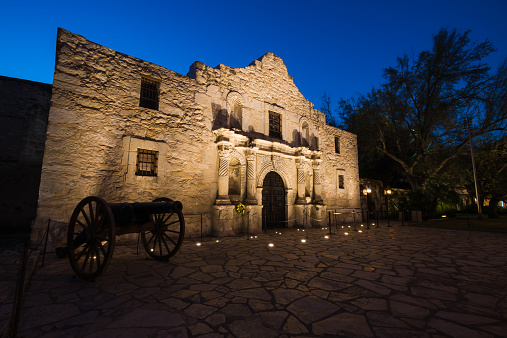 The illuminated Alamo Mission at twilight.