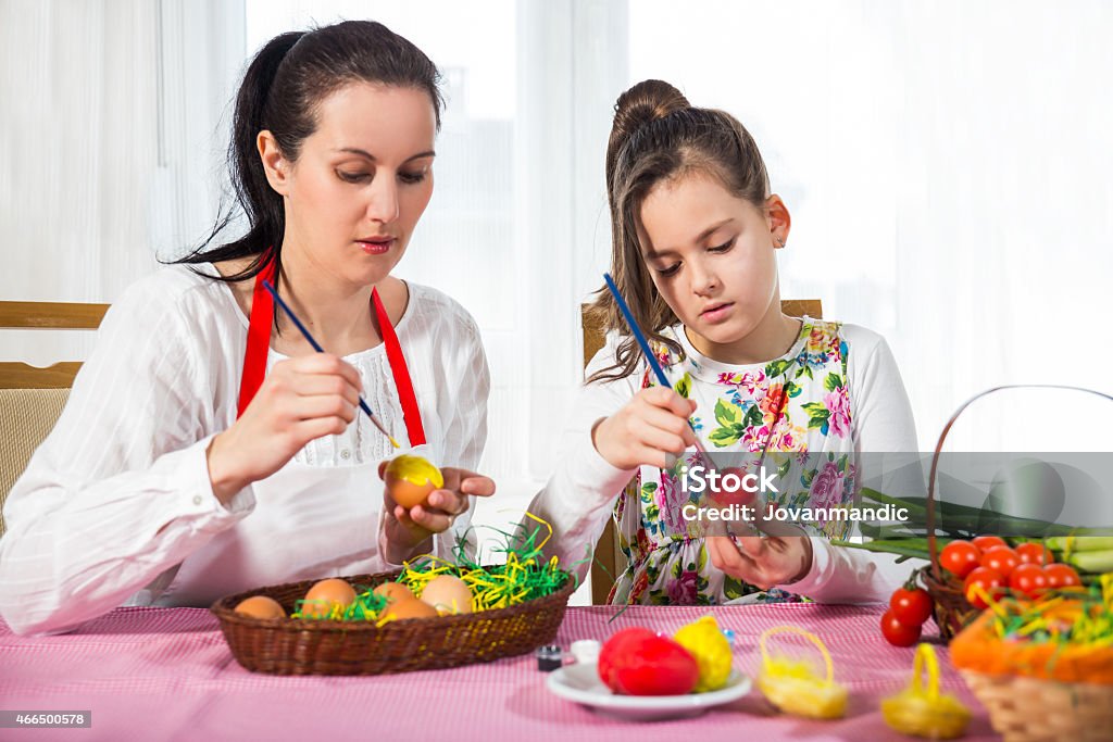 Mother with daughter coloring eggs for Easter. 2015 Stock Photo