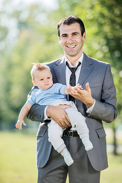 istock Businessman holding baby boy. 466502347