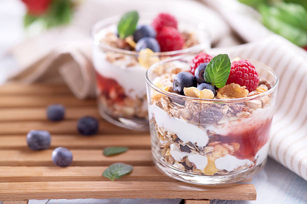 parfait, salsa di fragole con yogurt, muesli e frutta fresca - biscuit red blue macro foto e immagini stock