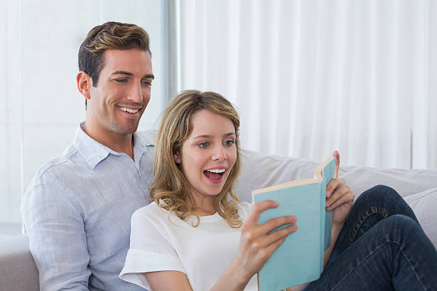 istock Relaxed loving couple reading book on couch 466502570