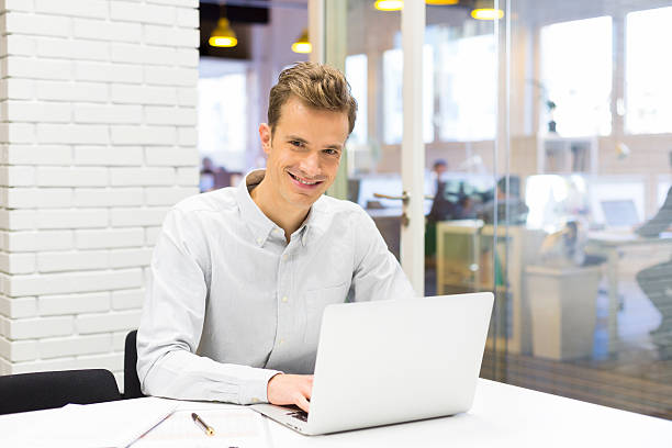 istock Happy man working on laptop in clear office 466504709