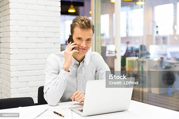 Junger Geschäftsmann Auf Handy Im Büro Stockfoto und mehr Bilder von Arbeitskollege - Arbeitskollege, Berufliche Beschäftigung, Büro