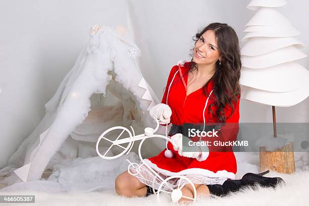 Girl Dressed As Santa Claus Plays With A Small Bike Stock Photo - Download Image Now