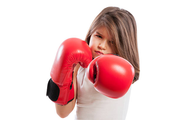 Young boxer girl in a fighting position wearing red boxing gloves and acting mad