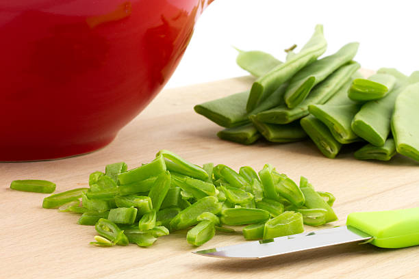 slicing running beans on cutting board