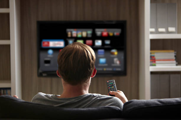 Man watching TV Man watching TV smart tv stock pictures, royalty-free photos & images