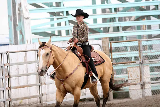 cowgirl contestant riding a horse in an arena during the fair and rodeo