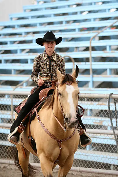 cowgirl contestant riding a horse in an arena during the fair and rodeo