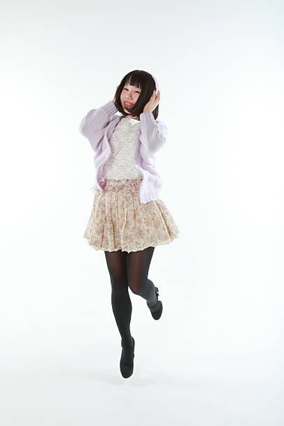 Studio portrait of a jumping girl in headphones listen music isolated