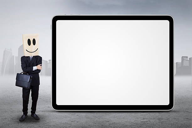 Person standing next to board outdoors Successful entrepreneur with a carton head standing next to empty billboard, shot outdoors anonymous businessman with paper bag on his head stock pictures, royalty-free photos & images