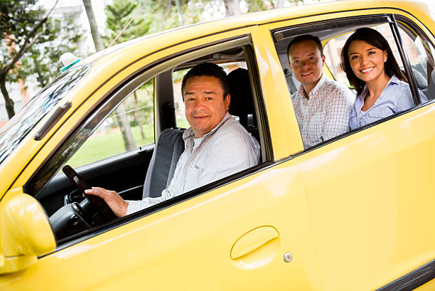 Taxi driver with passengers Taxi driver with passengers in the car looking happy taxi driver stock pictures, royalty-free photos & images