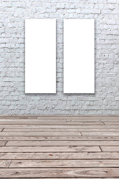 istock White painted brick wall with two white blank canvasses. 466512535