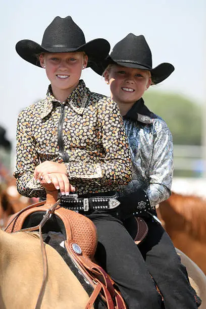 cowgirl contestants riding her horse in an arena during fair