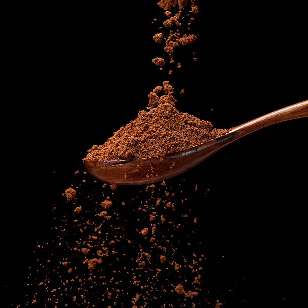 istock Ground coffee powder on a wooden spoon isolated on black 466513244
