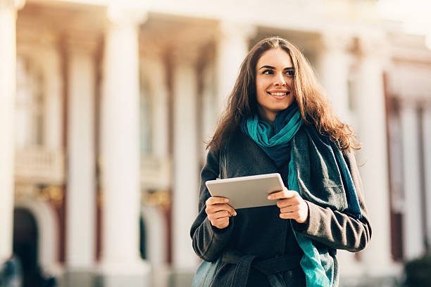 istock Pretty Young Woman using digital tablet outdoors 466513314