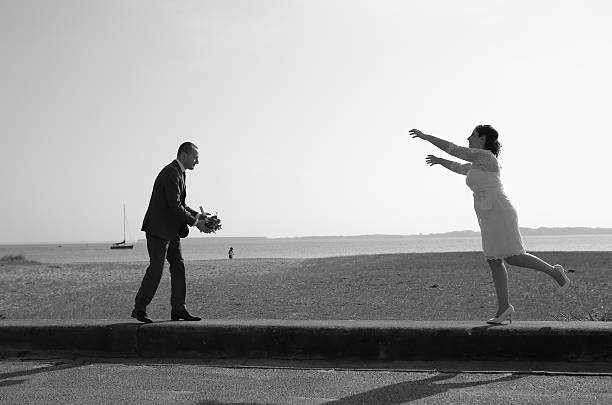 istock Bride and groom on pier play with wedding bouquet. 466516616