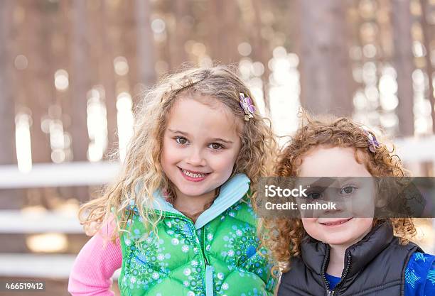 Closeup Of Two Young Sisters Smiling At Camera Stock Photo - Download Image Now - Pine Tree, Springtime, 2-3 Years