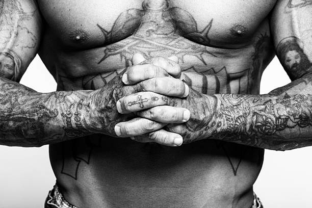 Bare chested man with religious tattoos. Bare chested adult caucasian man with religious tattoos. Black and white. White background. chest tattoo men stock pictures, royalty-free photos & images
