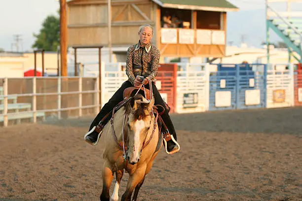 cowgirl contestant riding a horse in an arena during the fair and rodeo