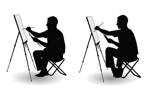The artist sitting at his easel and paints paints on canvas