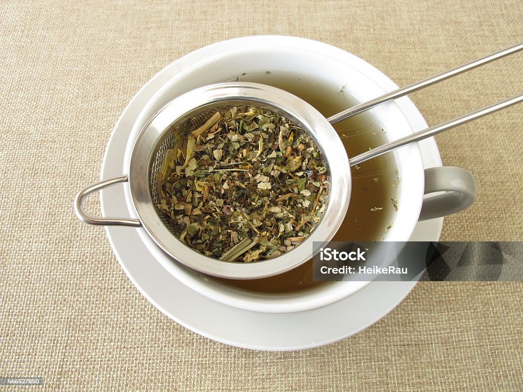 Herbal tea in tea strainer Herbal tea in tea strainer - Kräutertee im Teesieb Dried Tea Leaves Stock Photo