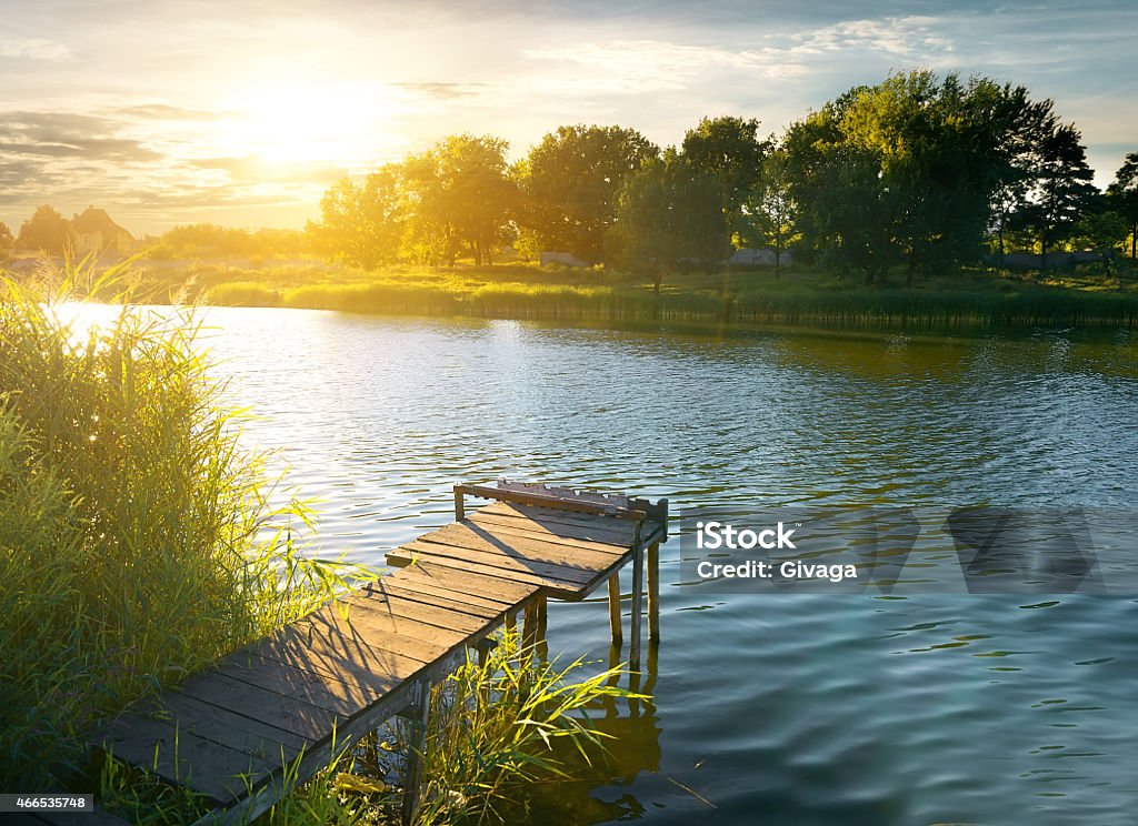 Pier in evening Wooden pier on a river in evening Fishing Industry Stock Photo