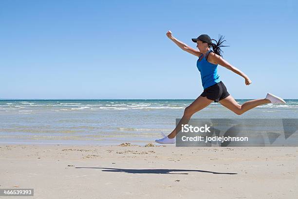 Fit Woman Leaping Mid Air On A Beach Stock Photo - Download Image Now - Active Lifestyle, Activity, Adult