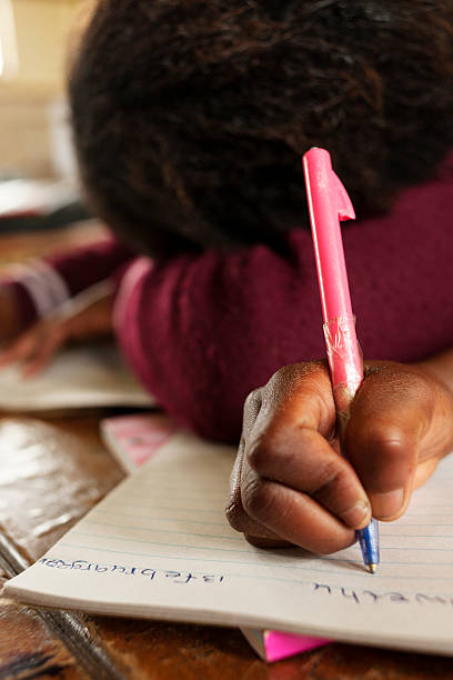 школа девушка, писать на бумаге с розовый перо - africa south africa child african culture стоковые фото и изображения