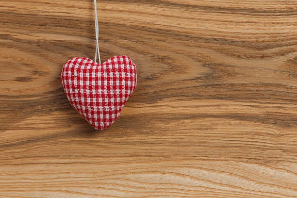 istock Gingham Love Valentine's heart hanging on wooden texture 466540531