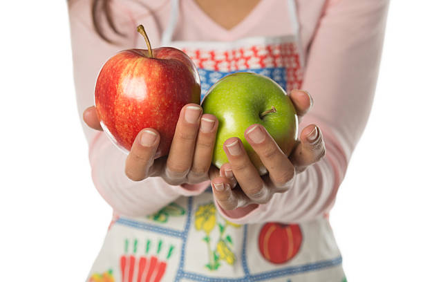 Zielone jabłka w ręce z Czerwone – zdjęcie