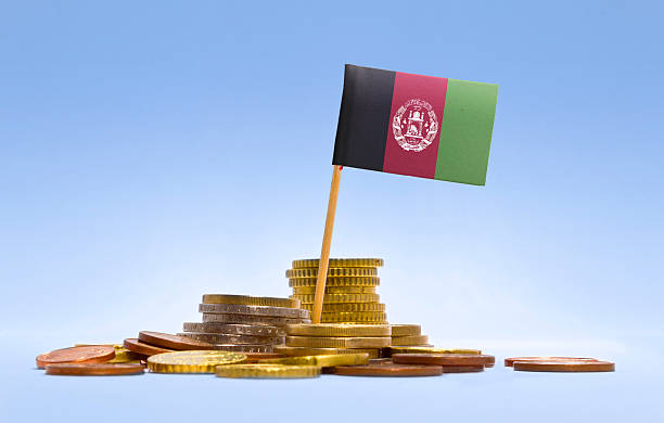 flagge von afghanistan in einem stapel coins. (serie) - support horizontal war afghanistan stock-fotos und bilder