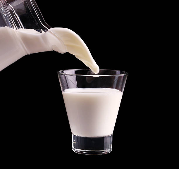 istock Splash in a glass with milk isolated on black 466549420