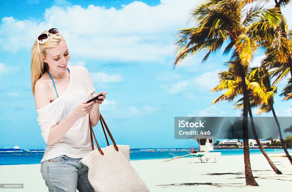 Smiling female using mobile in front of beach Smiling female using mobile in front of beachhttp://www.twodozendesign.info/i/1.png 20-29 Years Stock Photo