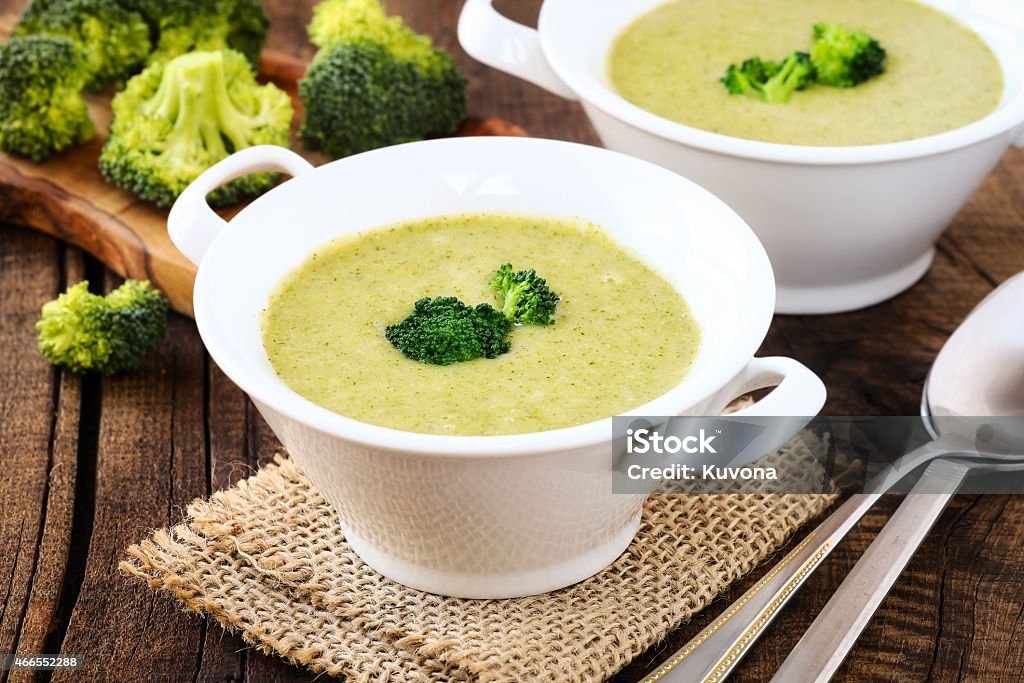 Cream of broccoli Healthy vegetarian cream of broccoli soup in white bowls on a rustic kitchen table Cream Of Broccoli Stock Photo