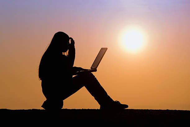 istock Girl working with laptop at sunset 466557857