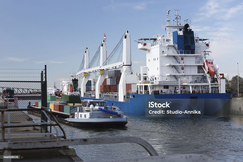Container ship and barge in Antwerp Modern cargo ship and river barge loaded with containers passing the Zandvliet lock in Antwerp port, the largest lock in the world (500m long) Barge Stock Photo