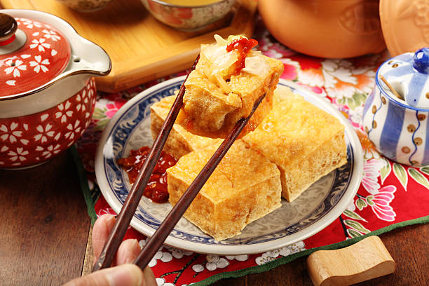 Plate of tofu being picked up with chopsticks