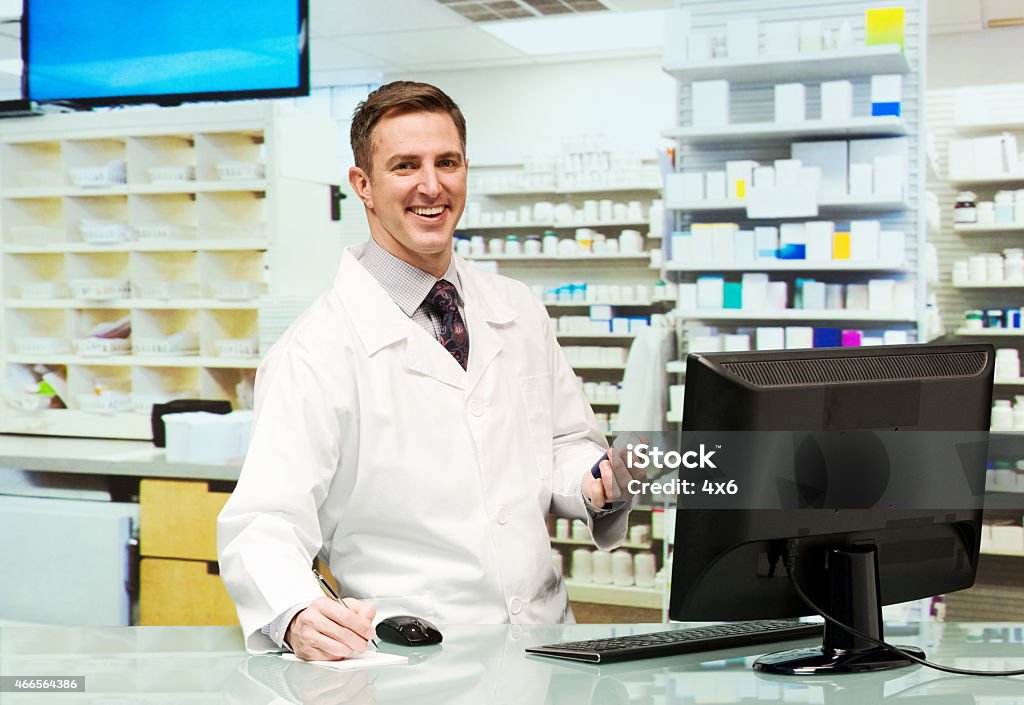 Smiling pharmacist working in drug store Smiling pharmacist working in drug storehttp://www.twodozendesign.info/i/1.png 2015 Stock Photo