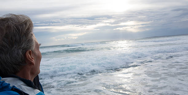 istock Man looks out across sea after storm 466564424
