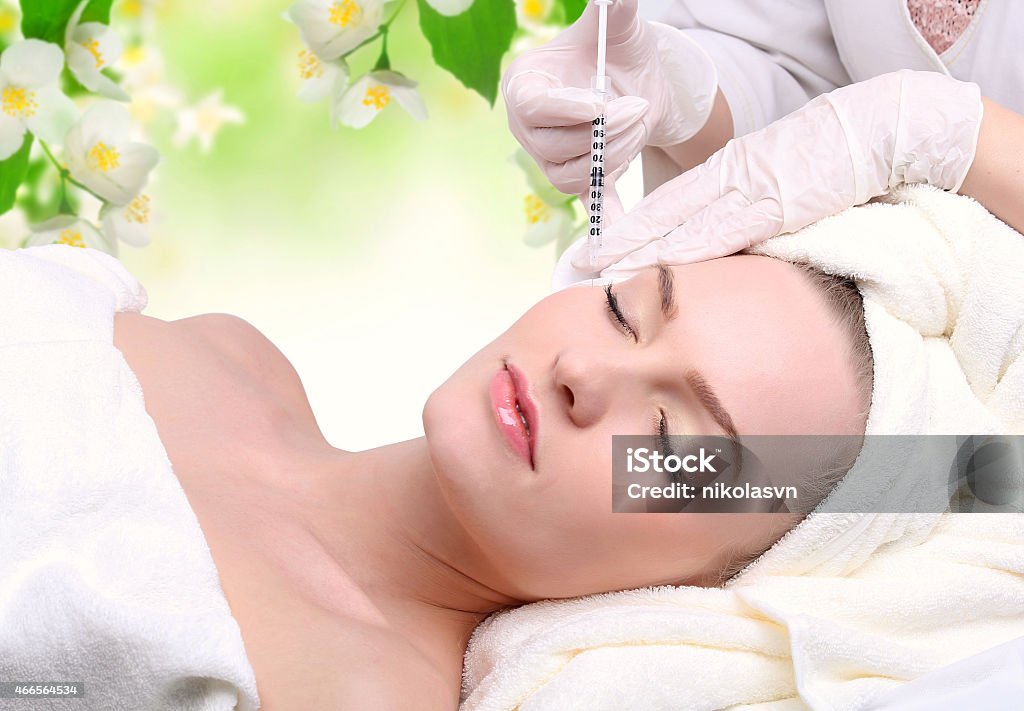 Injection in her face Beautiful woman gets an injection in her face 2015 Stock Photo