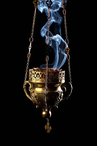 Hanging incense burner isolated on a black background