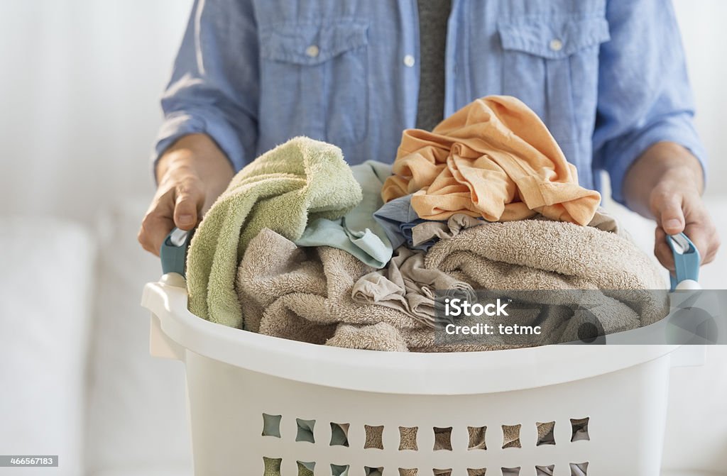 Hombre sostiene cesta de la ropa sucia en su hogar - Foto de stock de Cesta para la ropa libre de derechos