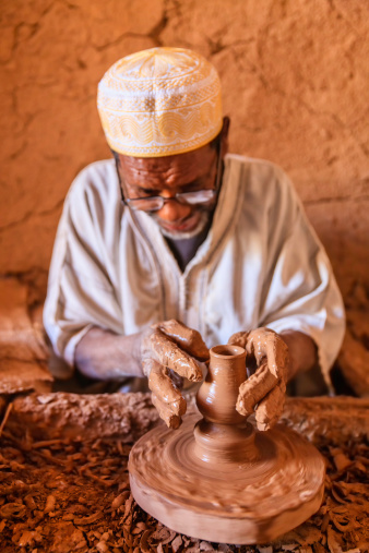 Moroccan potter working in the workshop on the pottery wheel near Ouarzazate, Morocco.http://bem.2be.pl/IS/morocco_380.jpg